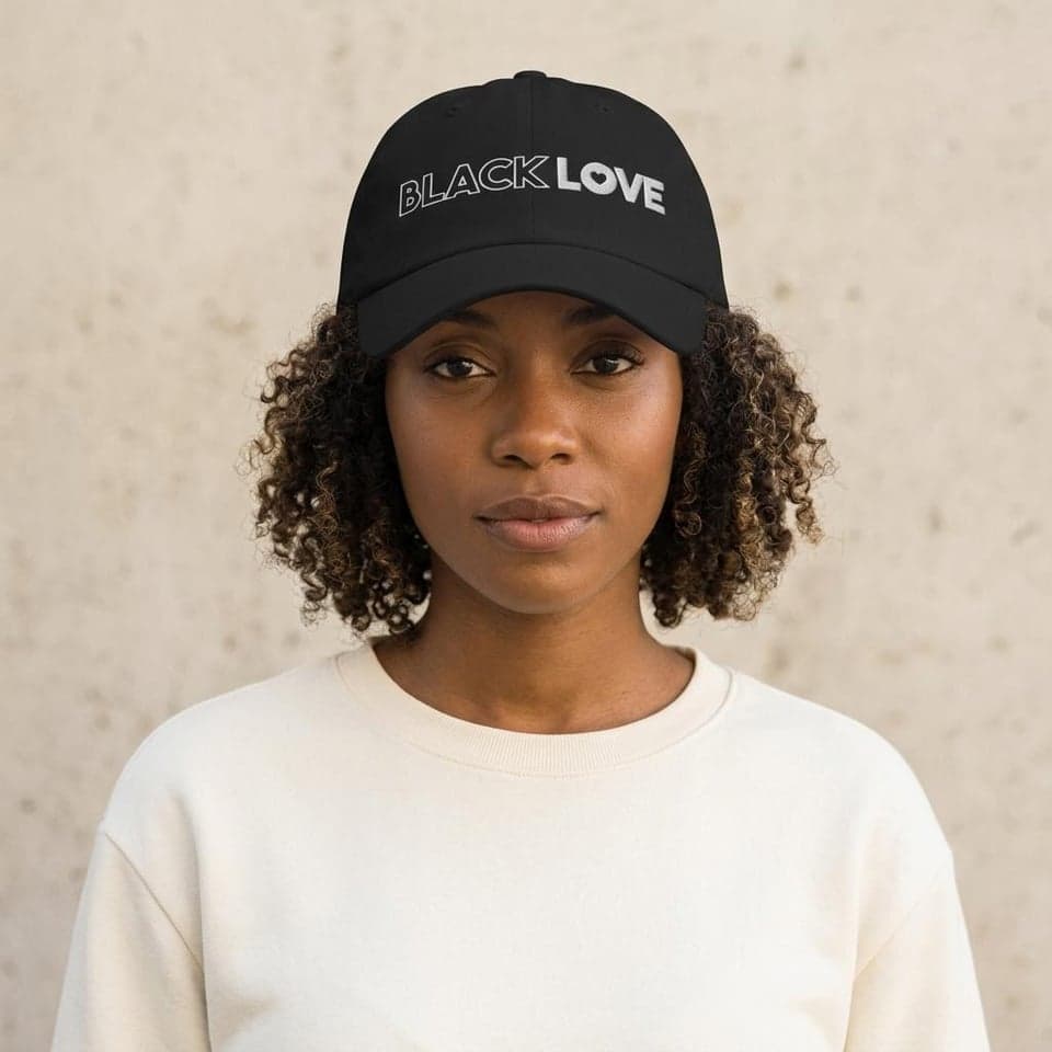 Woman wearing a black Black Love embroidered cap